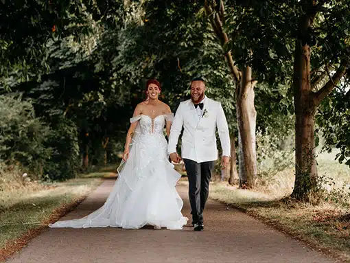 Bride and Groom in Lane walking hand in hand at That Amazing Place Essex Wedding Venue