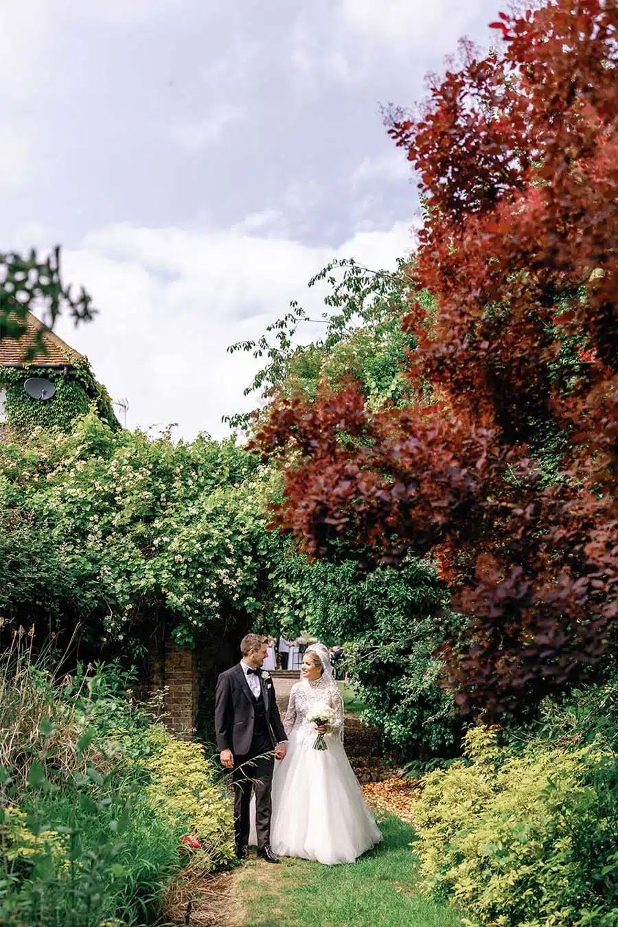 Bride and groom in secret garden walkway at That Amazing Place
