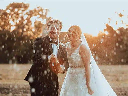 Bride and groom spraying champagne at That Amazing Place Essex Wedding Venue Old Harlow
