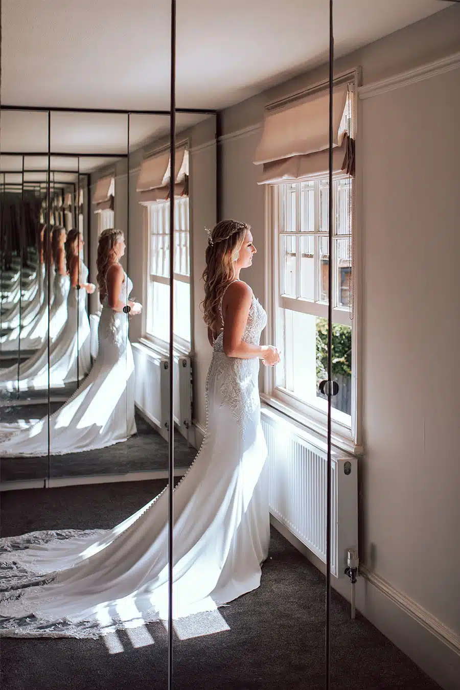 Bride at the window with mirrors at That Amazing Place Essex Wedding Venue The Lodge