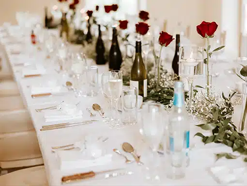 Long table for small intimate wedding breakfast with red roses at That Amazing Place essex wedding venue