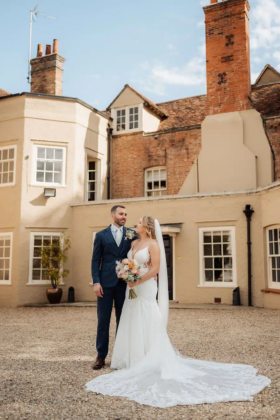 Portrait image of bride and groom outside house